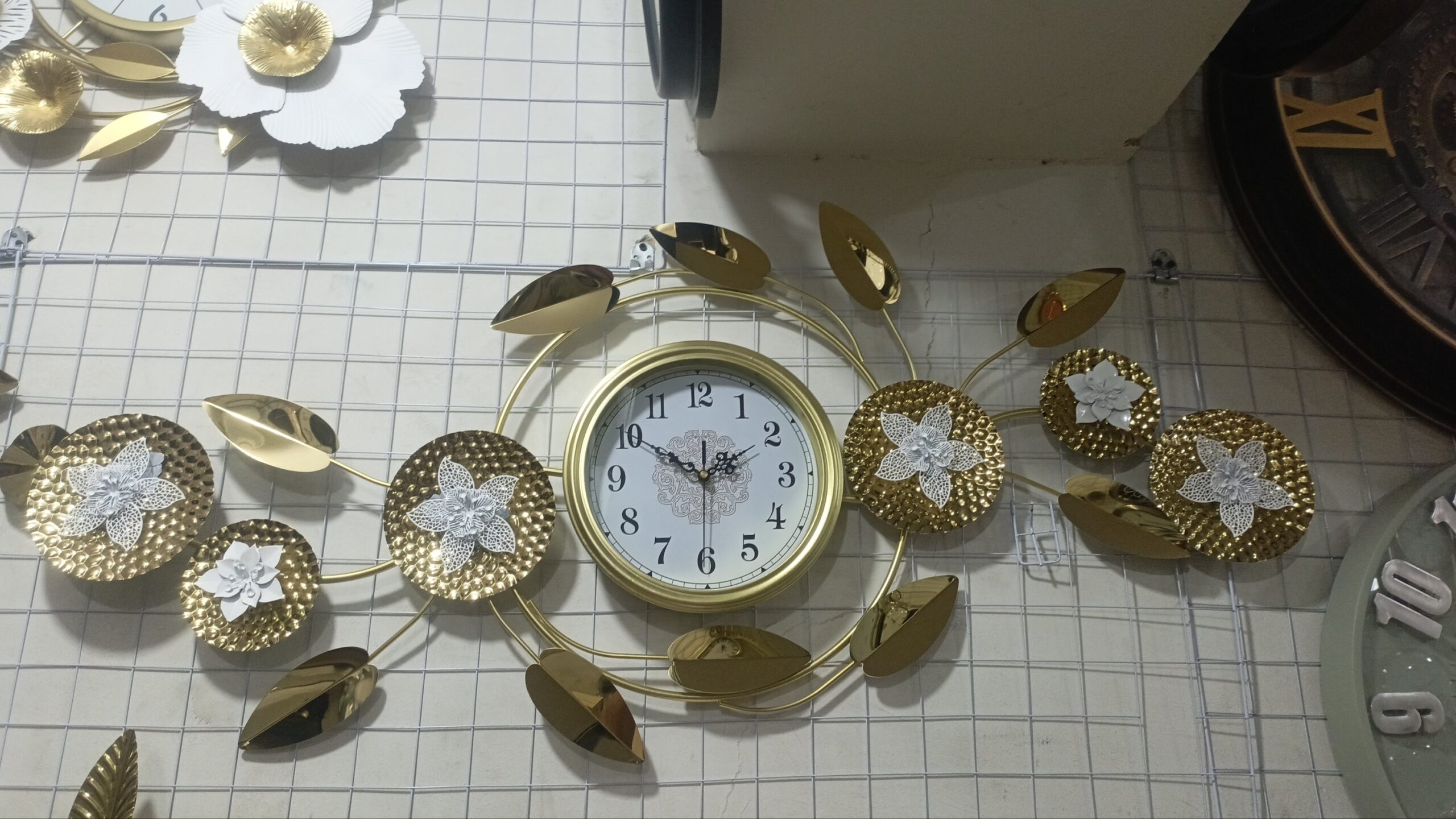 2025/12/1009650785-scaled.jpg Premium Quality Imported Metal Big Wall Clock With Golden & White 0rchid Leaf Design. - Image 1